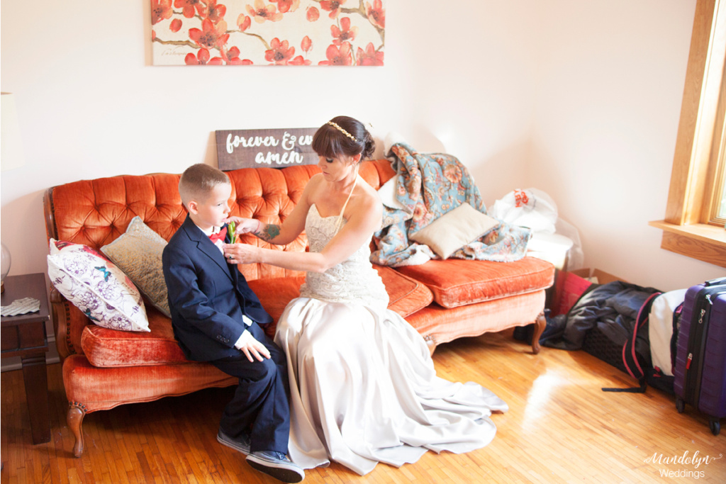 Son of the bride gets his tie adjusted by his mother.