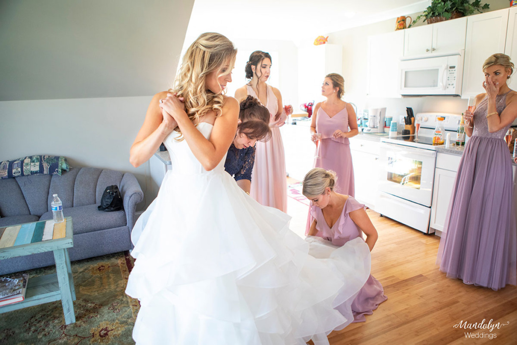 Bridesmaids helping the bride getting ready for her wedding. 
