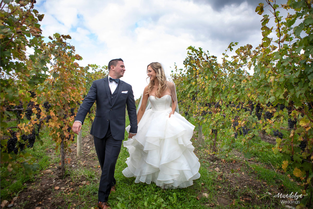 Bride and groom walking through the vineyard after first look. 